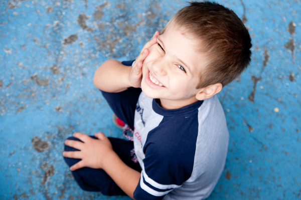 Foto di un bambino di 8 anni ripreso dall'alto che sorride e guarda in camera