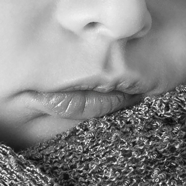 Dettaglio con il nasino e la bocca del neonatocon stoffa morbida a coprire parzialmente il mento. Bianco e nero
