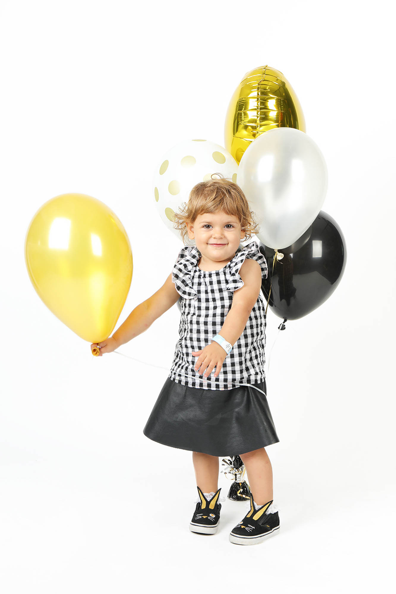 foto di una bella bimba che sorride, con tanti palloncini intorno