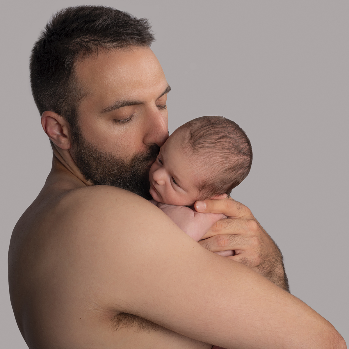 un papà felice che bacia il suo bimbo